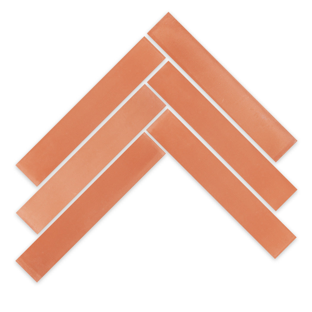 Six 2x12-Solid Terracotta samples by New York Cement Tile arranged in a chevron on a white background.