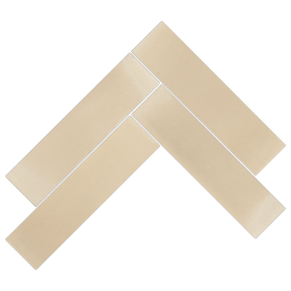 Four 2X8-Solid Heritage Beige subway tiles by New York Cement Tile in a herringbone pattern on white background.