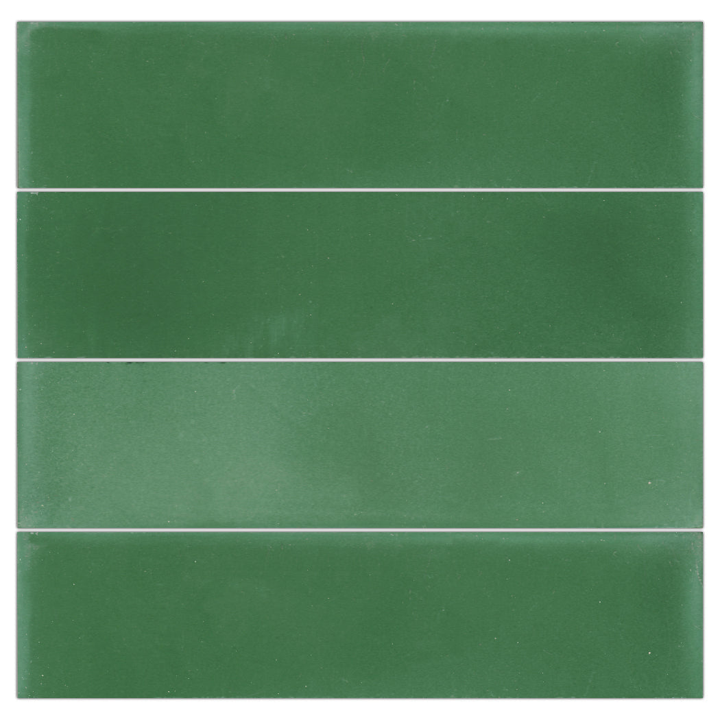 Four 2x8 Solid Verdant Hills tiles by New York Cement Tile, green with slim white gaps, create a stylish backsplash look.
