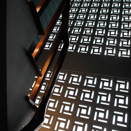 View looking up a staircase beside a Carabado Sample wall by New York Cement Tile letting in natural light.