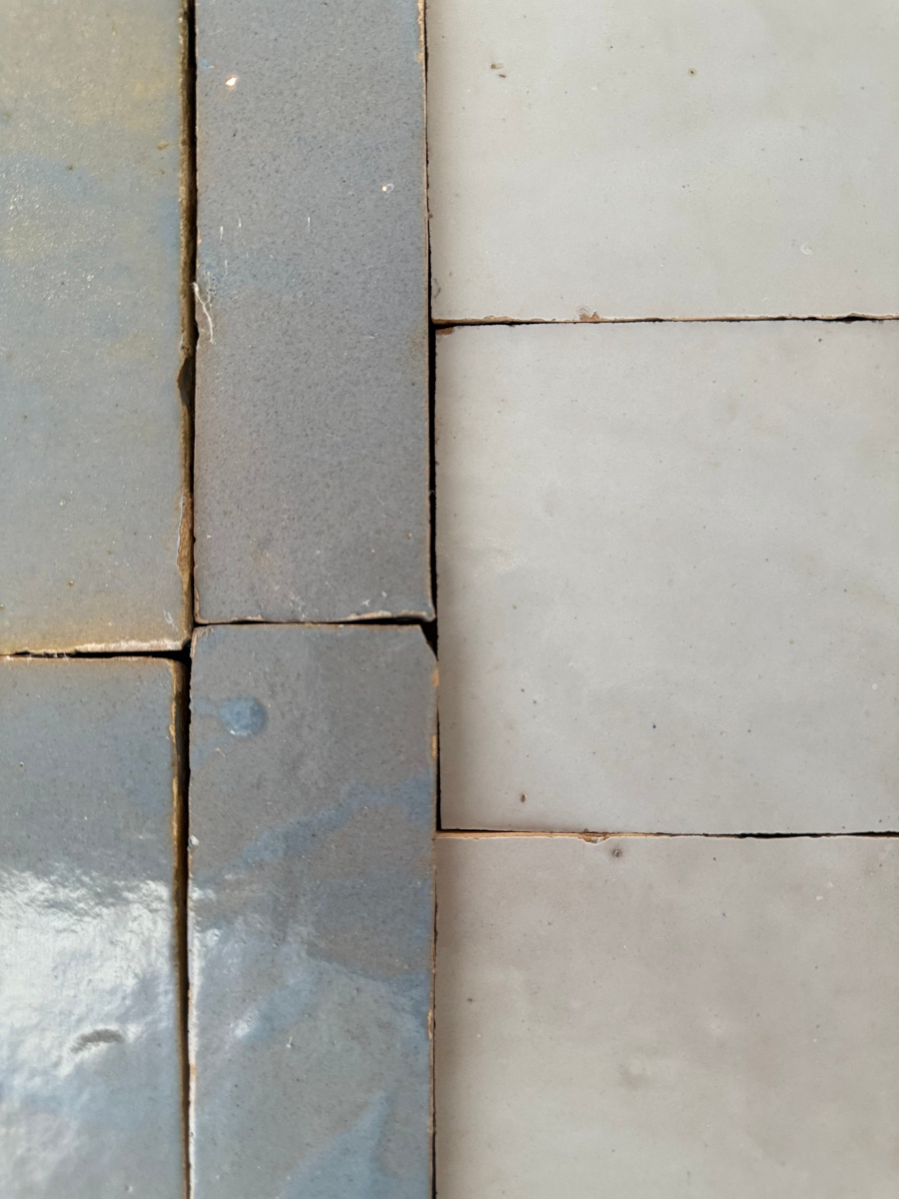 Close-up of New York Cement Tile's Magical Blue Zellige meeting matte white tiles, grout lines in between.