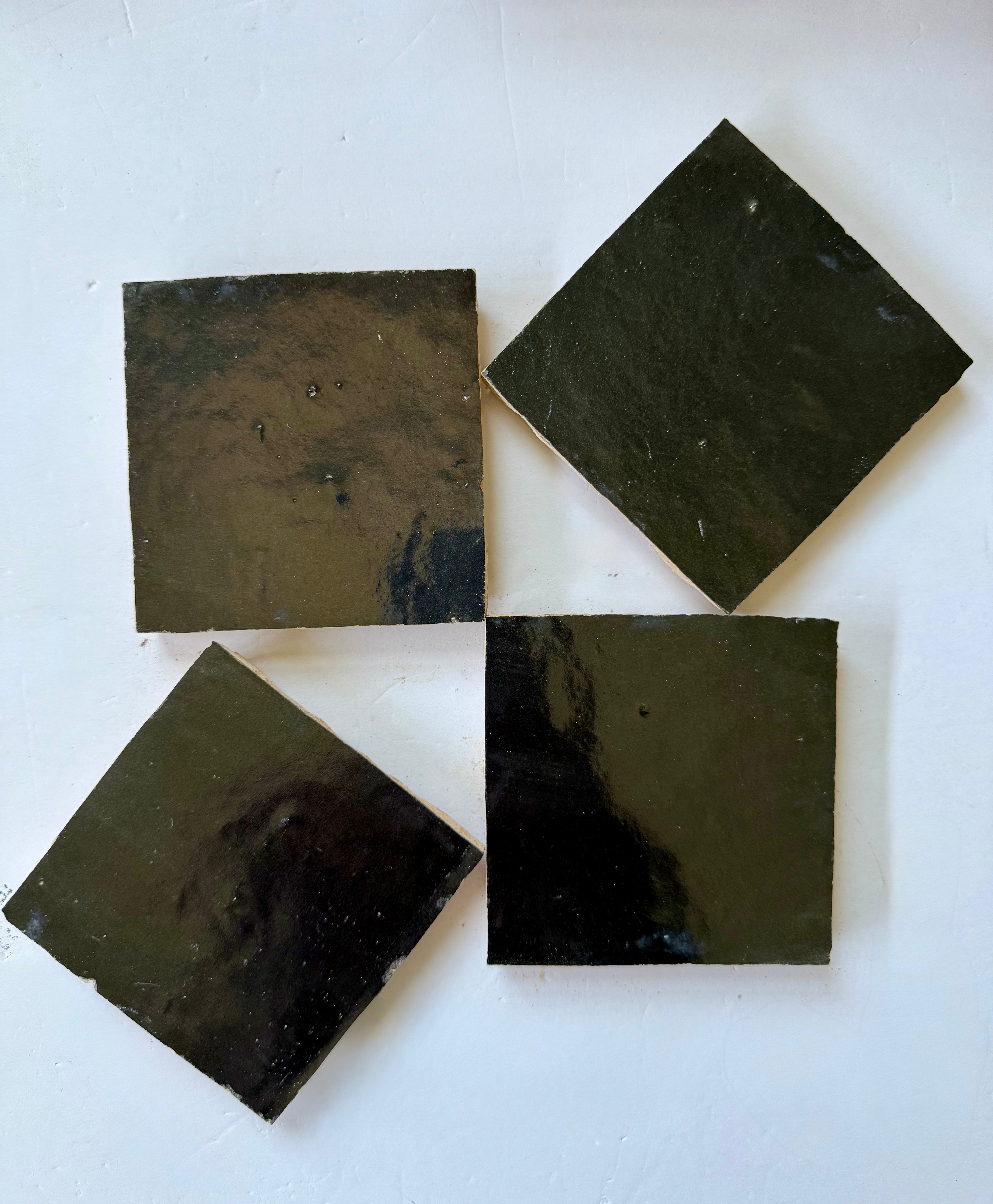 Four Metallic Black Onyx tiles by New York Cement Tile arranged like shiny handcrafted tile in a diamond pattern on white.