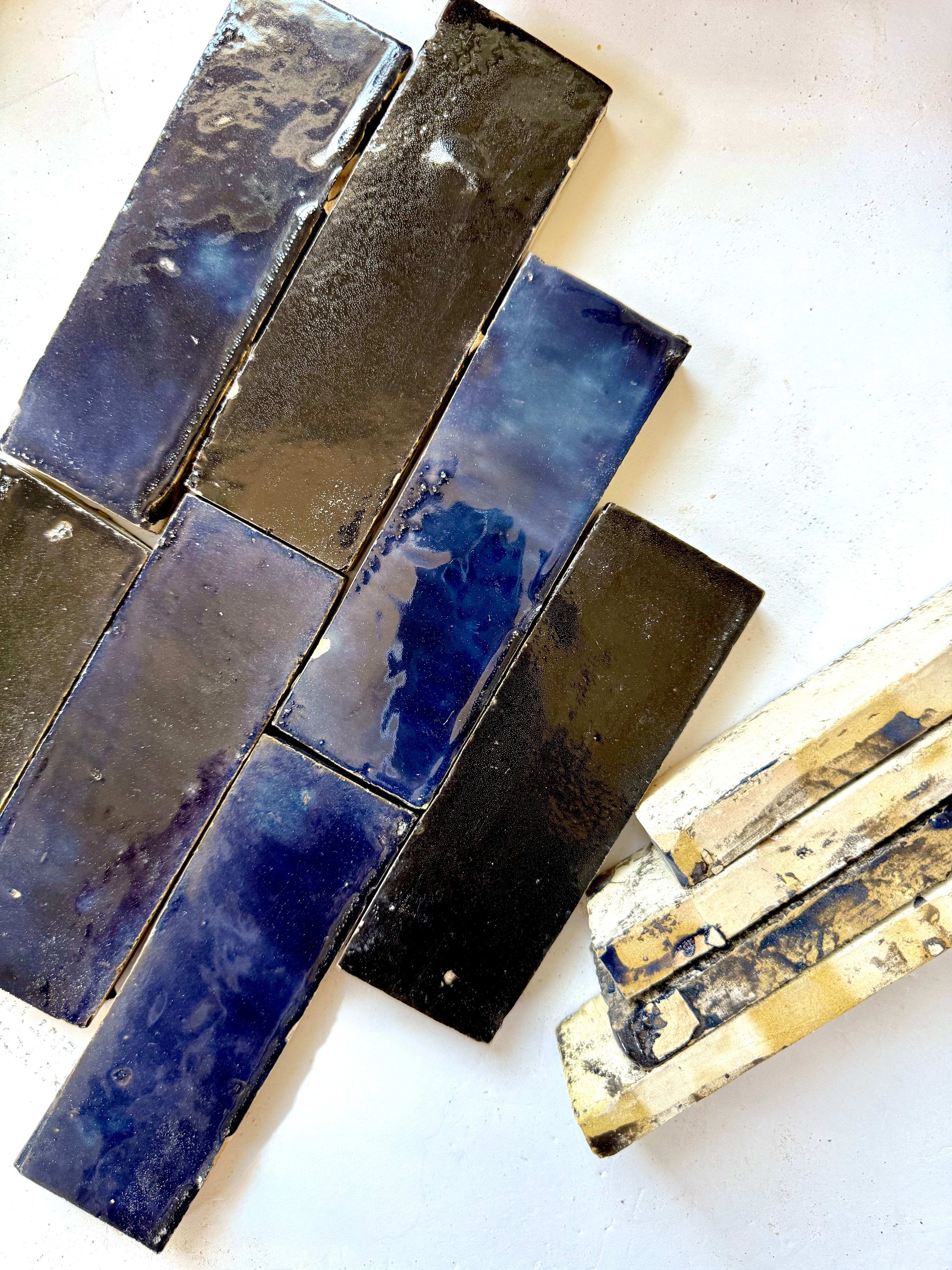 Metallic Blue (2X6) tiles by New York Cement Tile in a staggered layout pair with stacked off-white natural clay tiles.