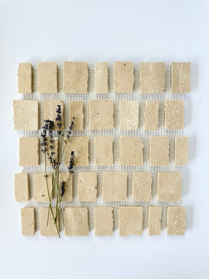Scarpa I Travertine Mosaic Marble Mesh by New York Cement Tile, arranged with lavender on a white background.