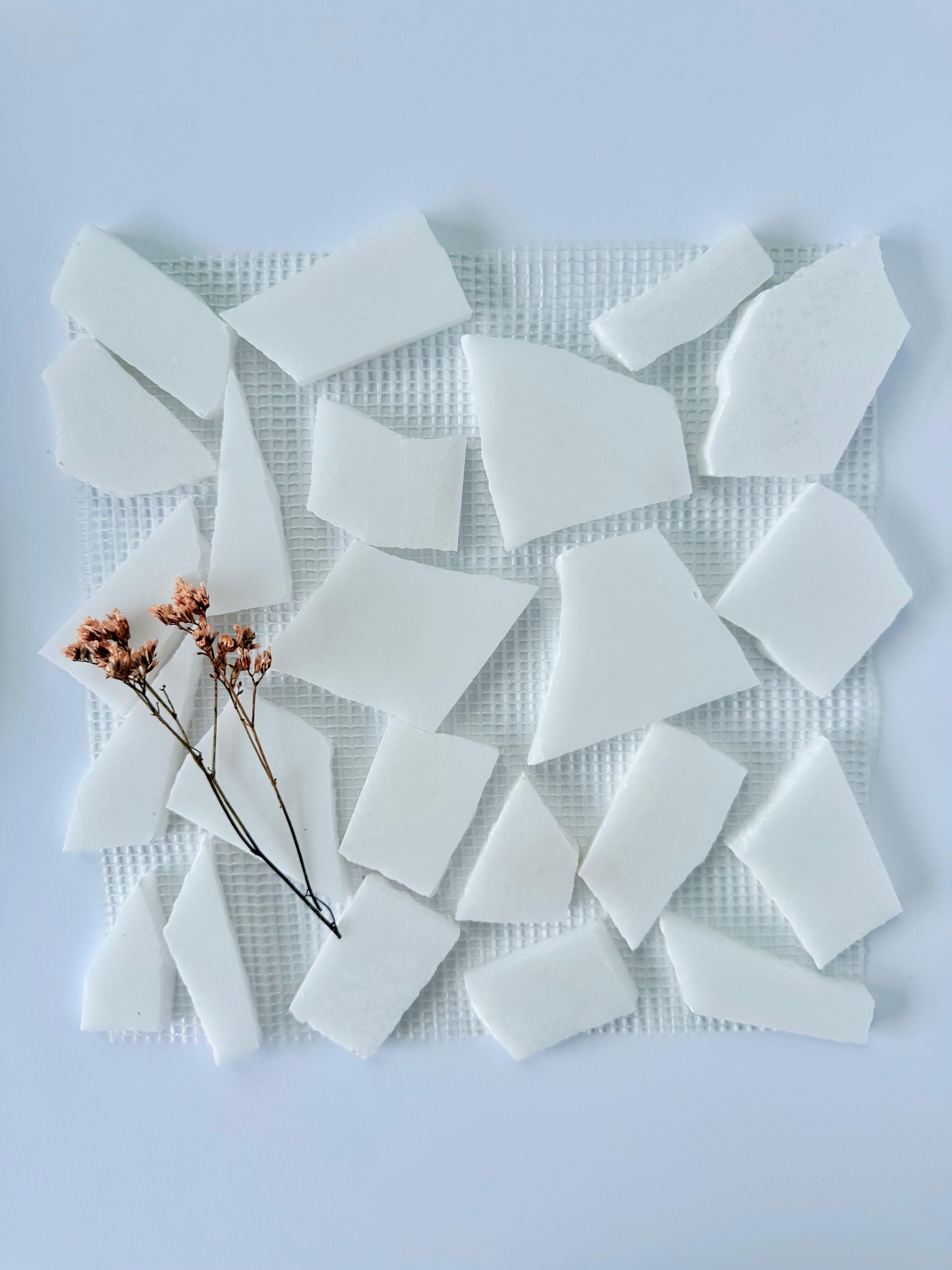 Ice Break - Puzzle Mosaic Marble Mesh by New York Cement Tile, arranged on a mat with dried flowers against white.