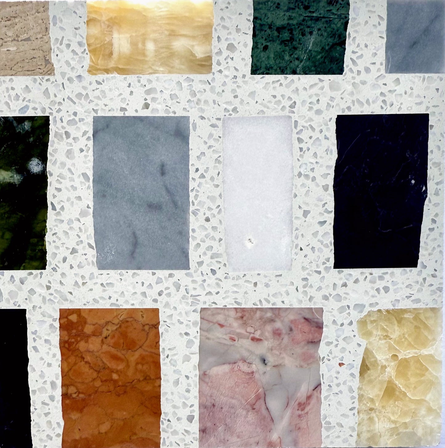 The Carlo Scarpa-Multicolor by New York Cement Tile features a terrazzo surface with green, orange, black, white & gray inlays.