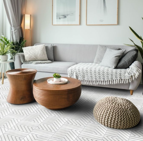 Modern living room with a gray sofa, wood tables, plants, and a Circuitry Dover tile rug by New York Cement Tile.