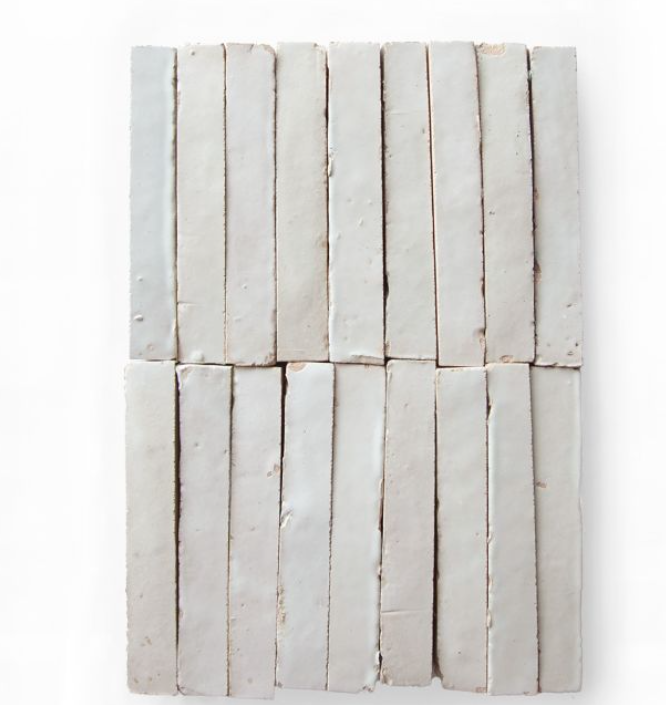 Rectangular Slim Glazed Ivory Cloud (5½"x⅞") tiles by New York Cement Tile are arranged in a grid on a white background.