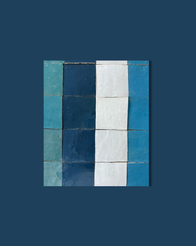 Navy Depths tiles by New York Cement Tile feature a blue and white handcrafted grid pattern on a deep navy background.