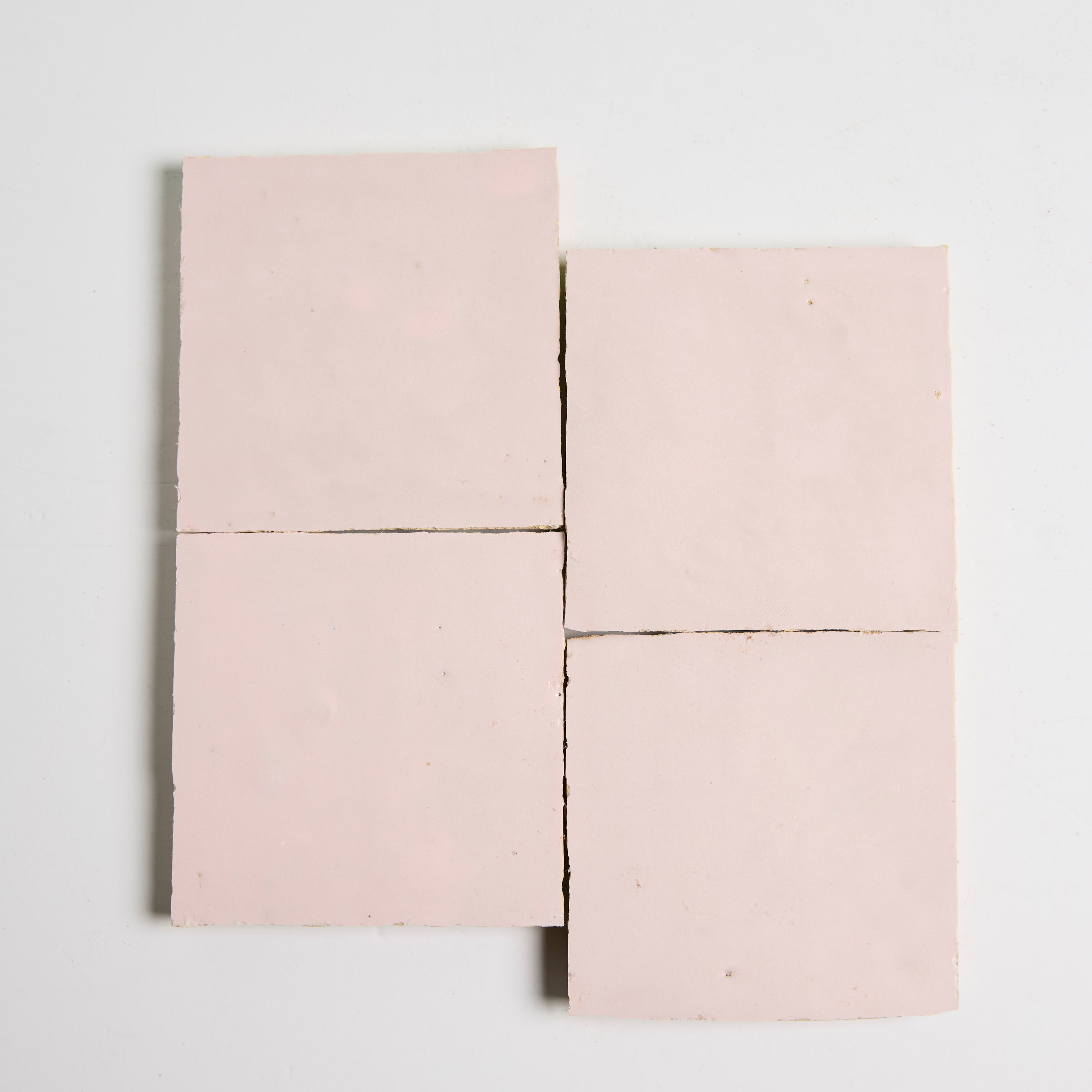 Four slices of Rosy Pink by New York Cement Tile, arranged in a grid like handcrafted tiles on a white surface.