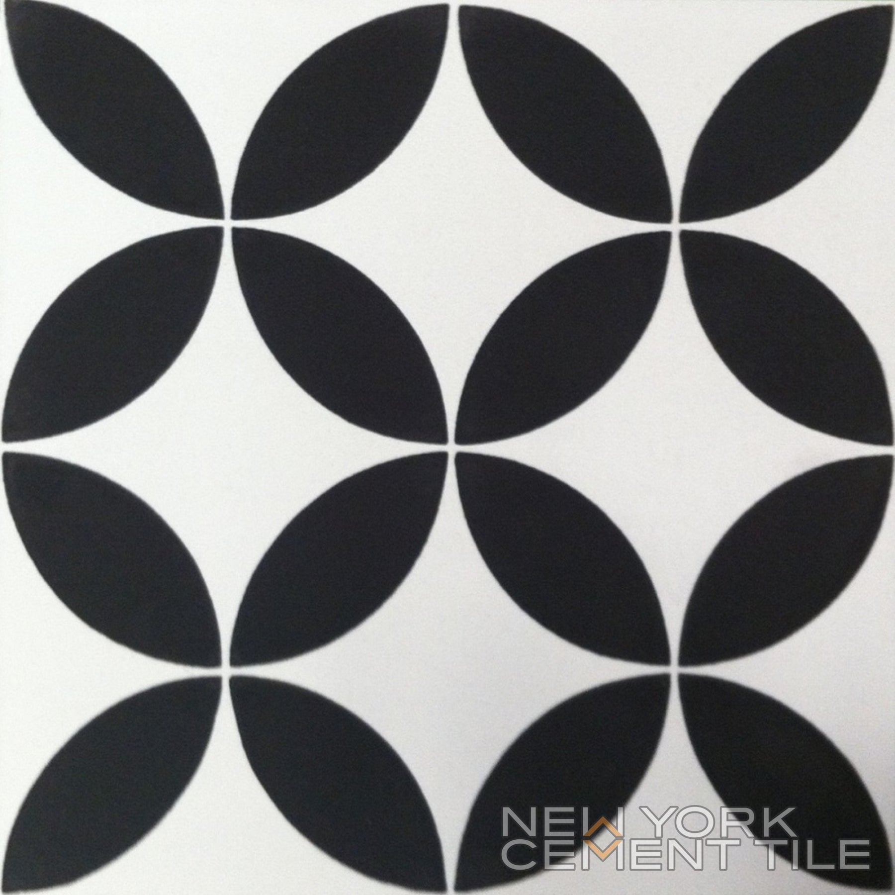 N20-061 Sample by New York Cement Tile features a black geometric floral pattern on white, logo in the corner.