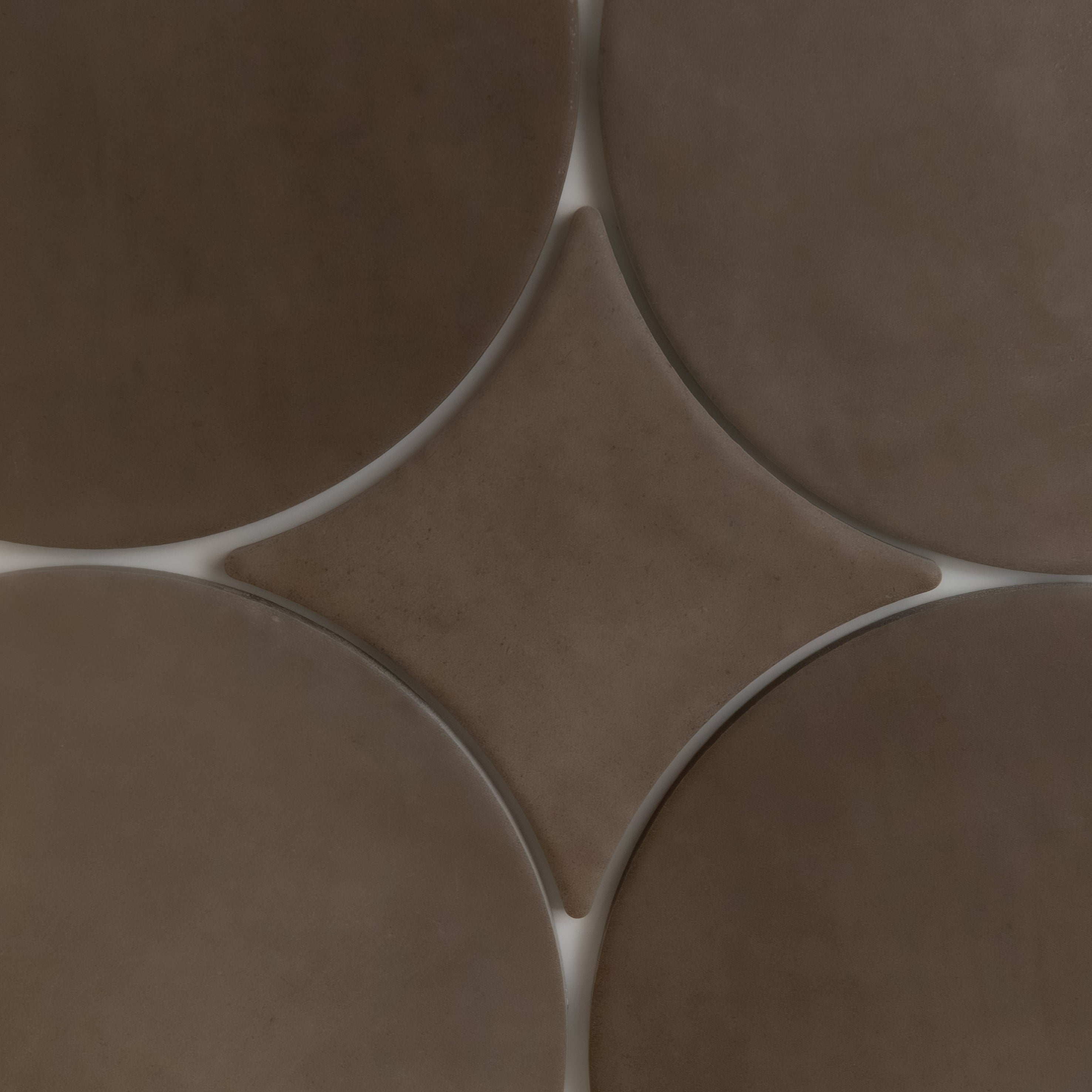 Finca’s Alpaca tiles feature brown circles and diamonds, forming a geometric pattern with smooth, subtly shaded surfaces.