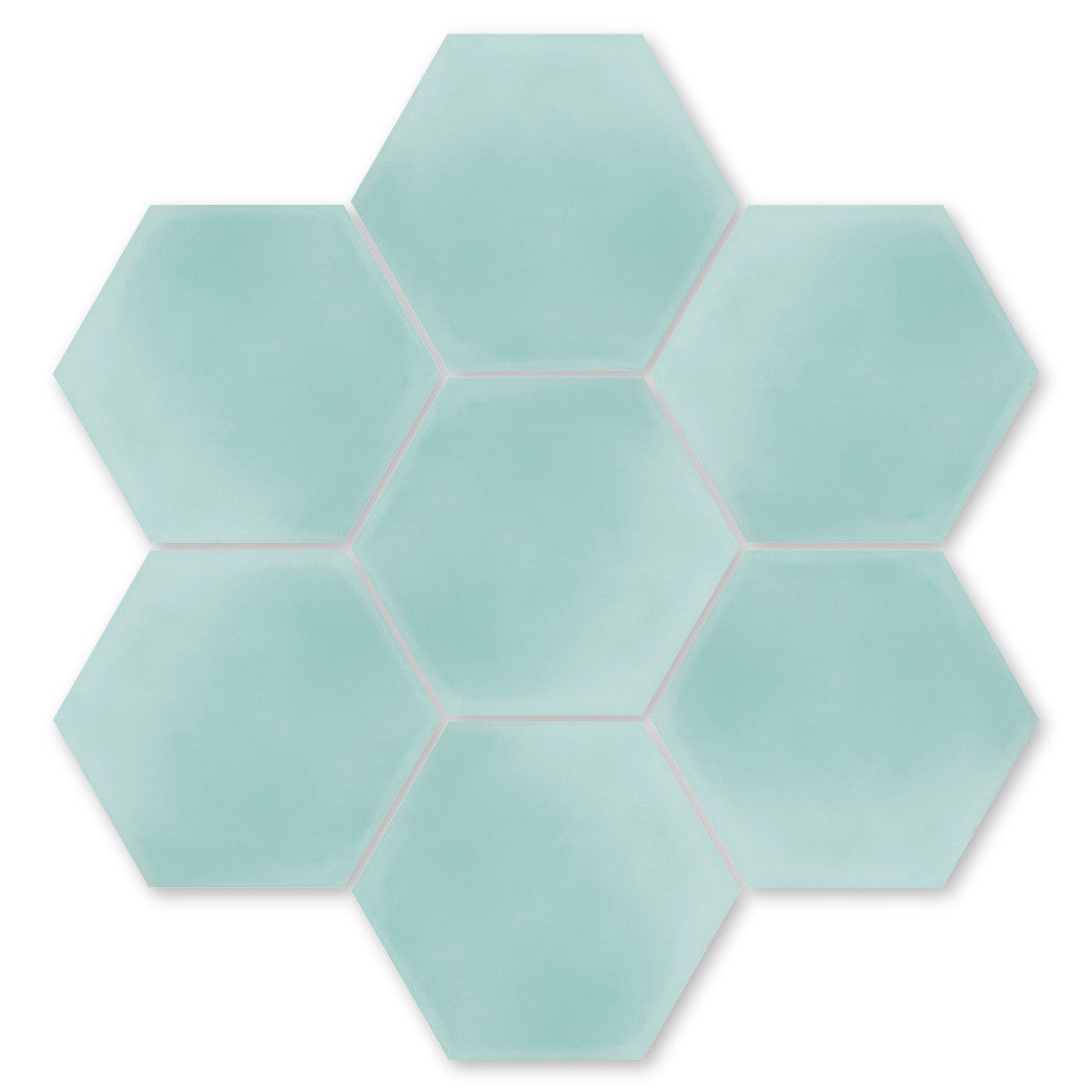 Seven NH23-3309 hexagonal tiles by New York Cement Tile in light blue, arranged on a white background.