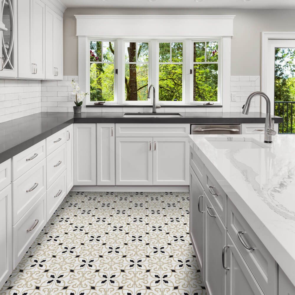 Bright kitchen with Charlotte Primero tiles by New York Cement Tile, white cabinets, gray counters & large windows over greenery.