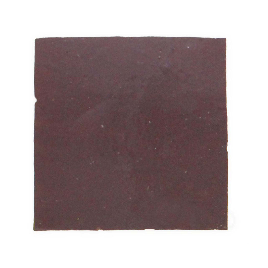 A single Deep Plum 2X2 tile sample from New York Cement Tile sits on a plain white background, resembling dark chocolate.