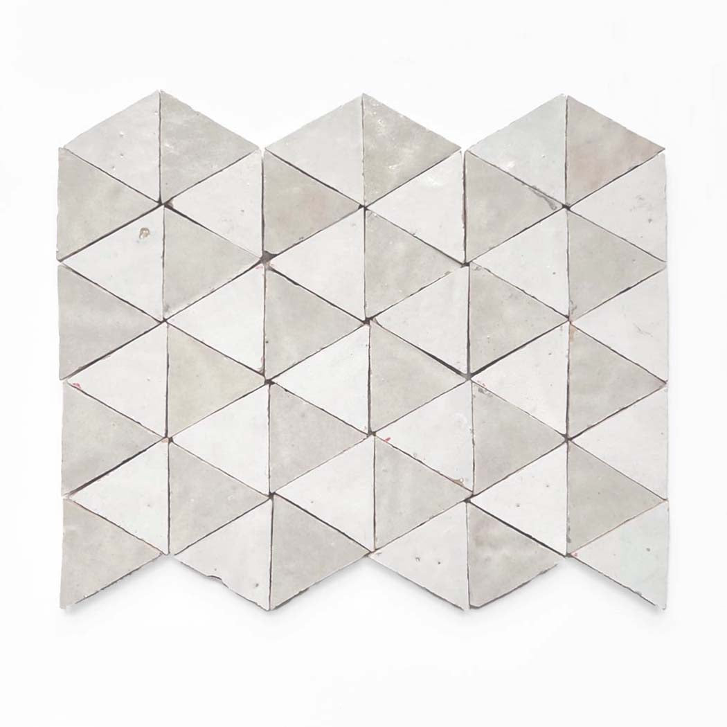New York Cement Tile's Glazed Zellige Mosaic Mat Triangles in Pearl Grey Shell create a geometric pattern on a white background.