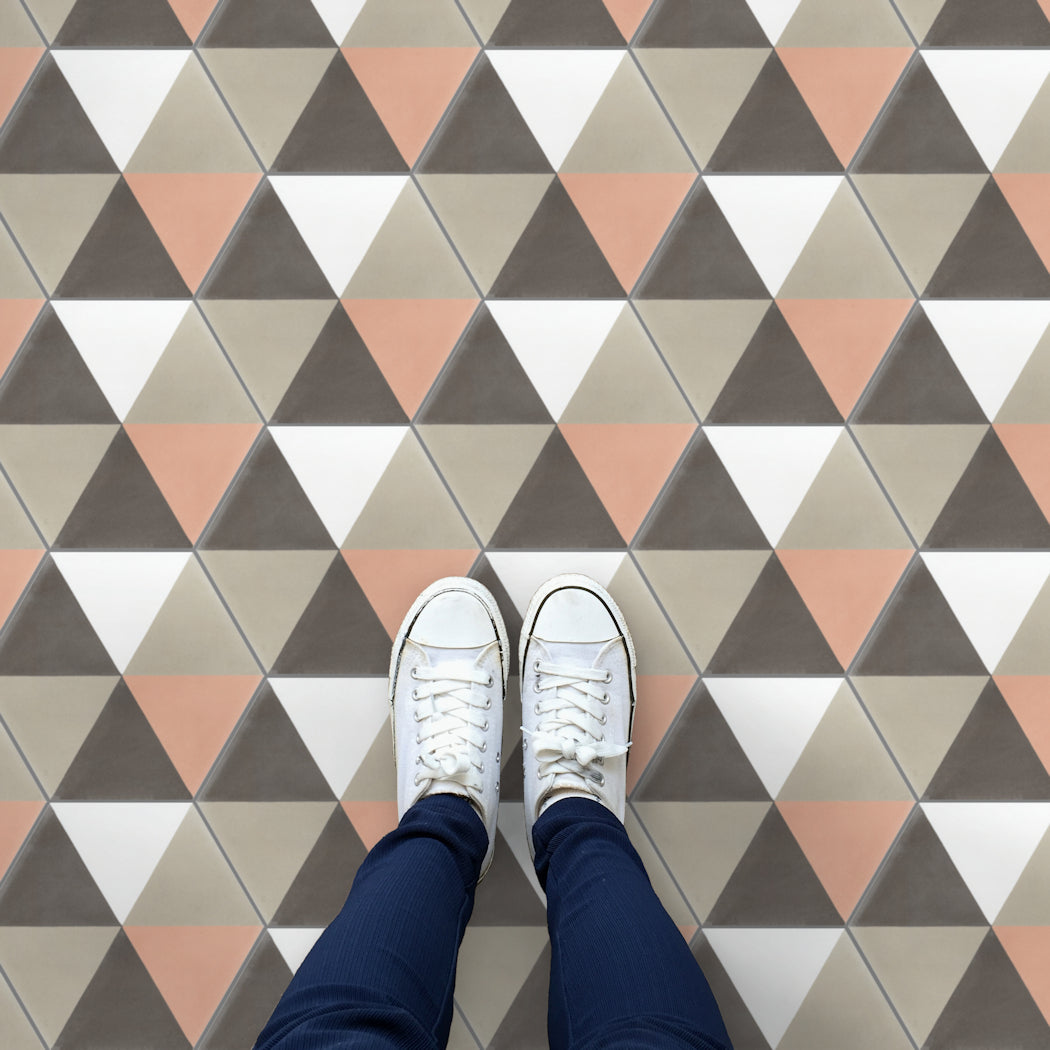 A person in white sneakers and blue pants stands on New York Cement Tile’s Hex Pie Neapolitan geometric tile floor.