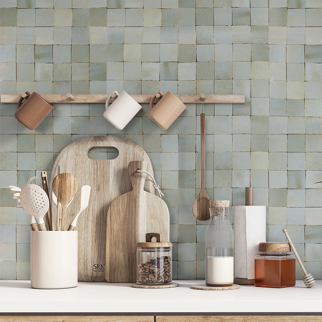 Arctic Blue tile by New York Cement Tile sets off wood utensils, jars, and cutting boards on a kitchen countertop.