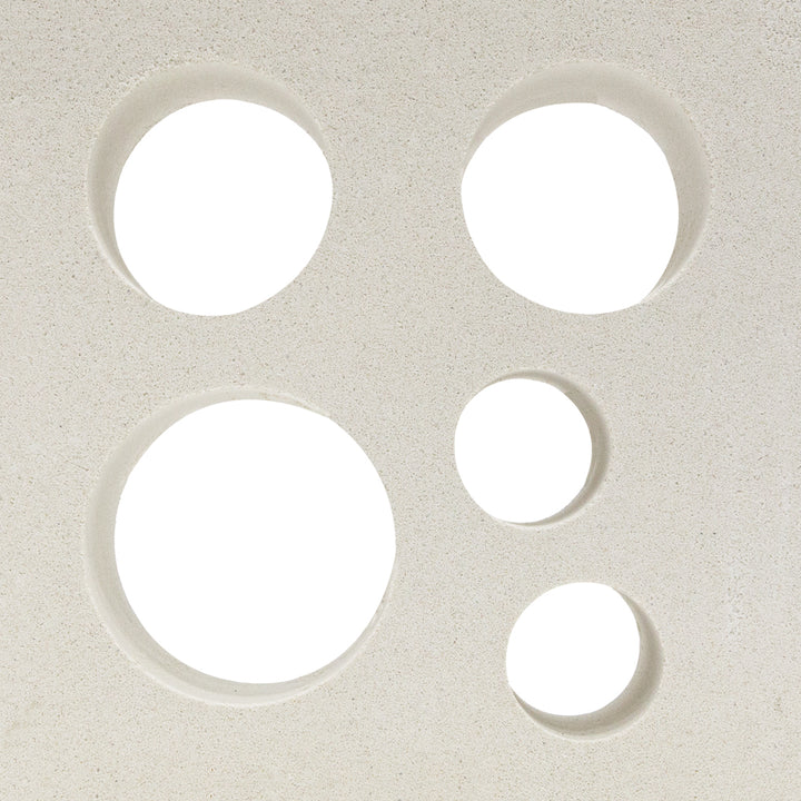 Jami by New York Cement Tile features five unevenly clustered circular holes on a textured white surface, evoking breeze blocks.