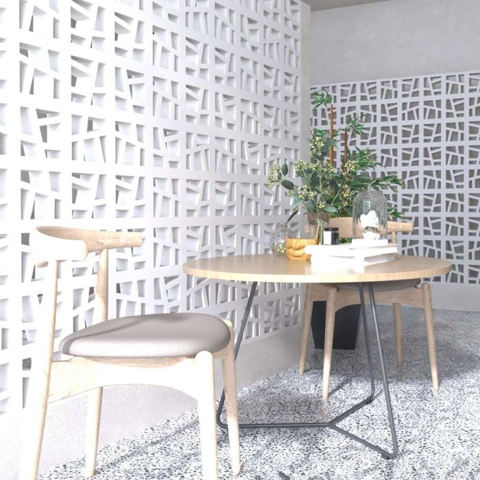 A modern dining area with light wood, Large Kyush partitions by New York Cement Tile, and plants on a round table.