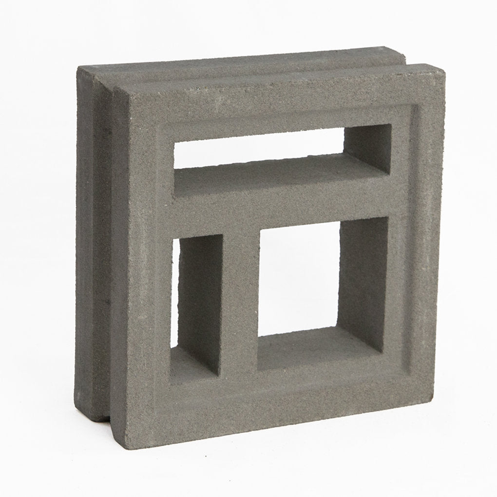 The Katai Sample by New York Cement Tile is a gray concrete breeze block with geometric cut-outs, ideal for modern partitions.