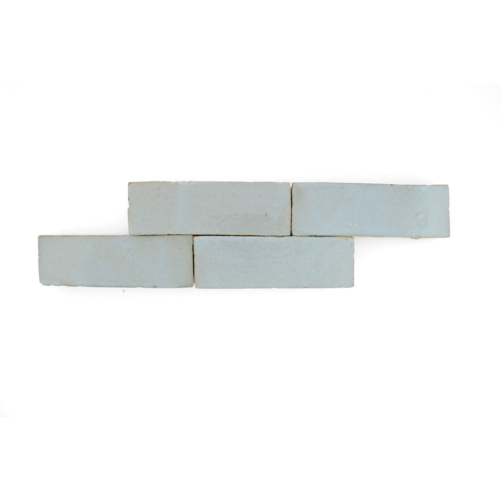 Four Arctic Blue (2x6) sample tiles by New York Cement Tile, staggered in a row on a white background.