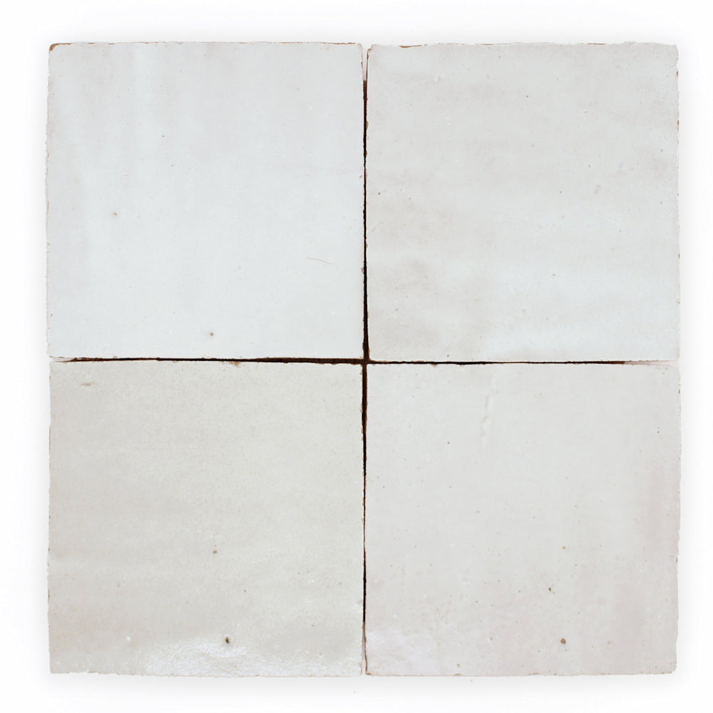 Four Ivory Cloud 2X2 tiles by New York Cement Tile, off-white and handcrafted, are set in a square with dark grout lines.