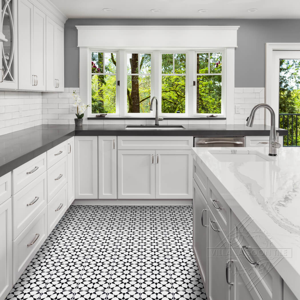 Bright kitchen with white cabinets, black counters, N20-271 White & Black tile by New York Cement Tile, and large windows.