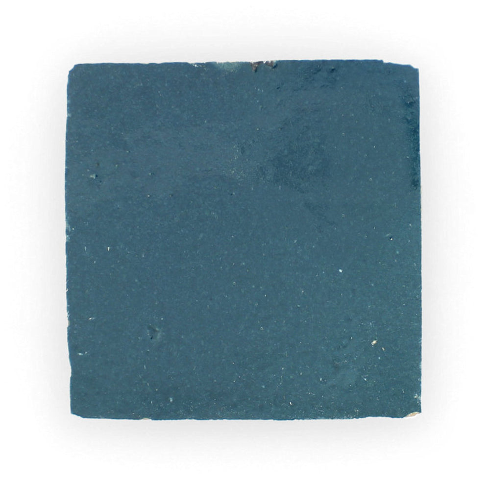 Sea Breeze sample by New York Cement Tile: a square, matte slate blue tile with rough edges on a white background.