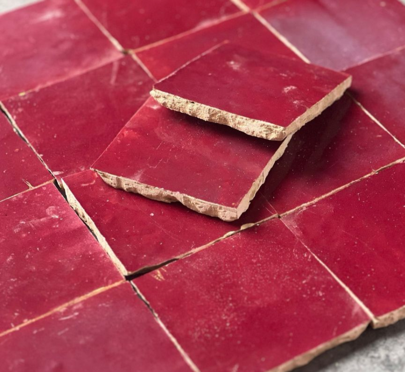 Several red square tiles are arranged together, with two stacked at an angle on top of the others.