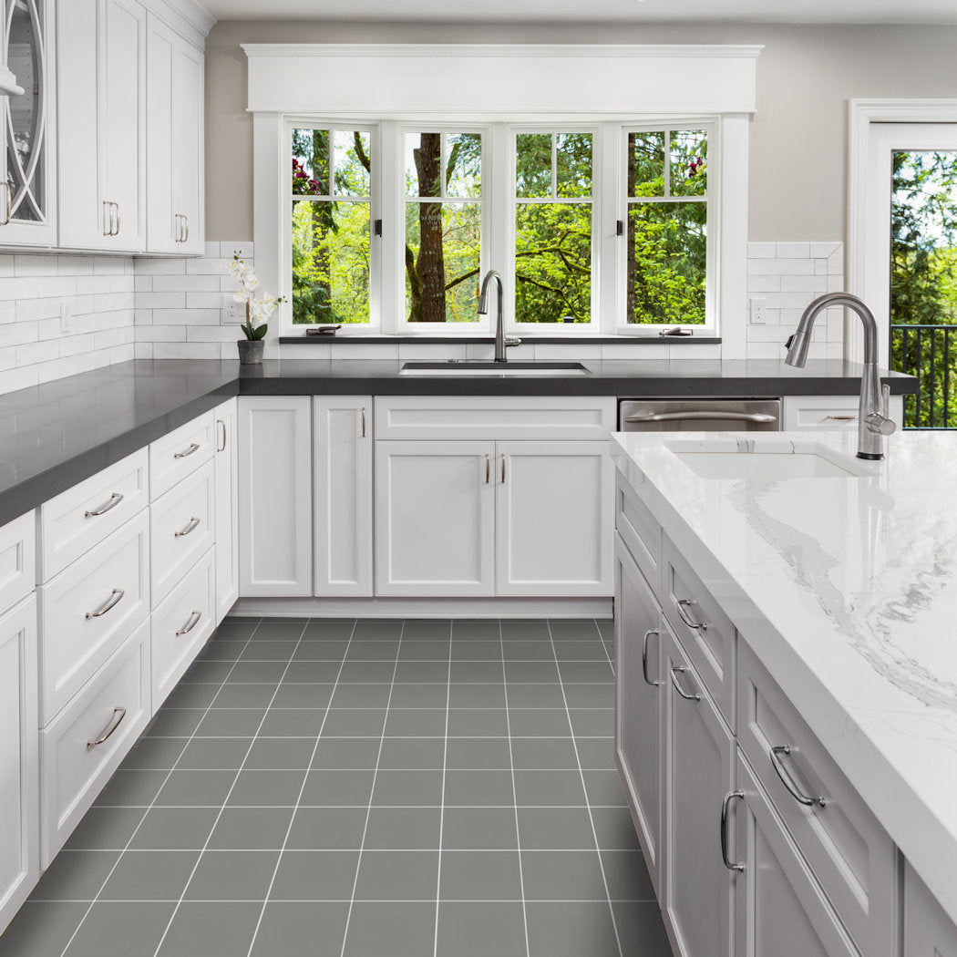 Modern white kitchen with 2202-Solid gray countertops by New York Cement Tile, tiled floor, large windows, and tree views.