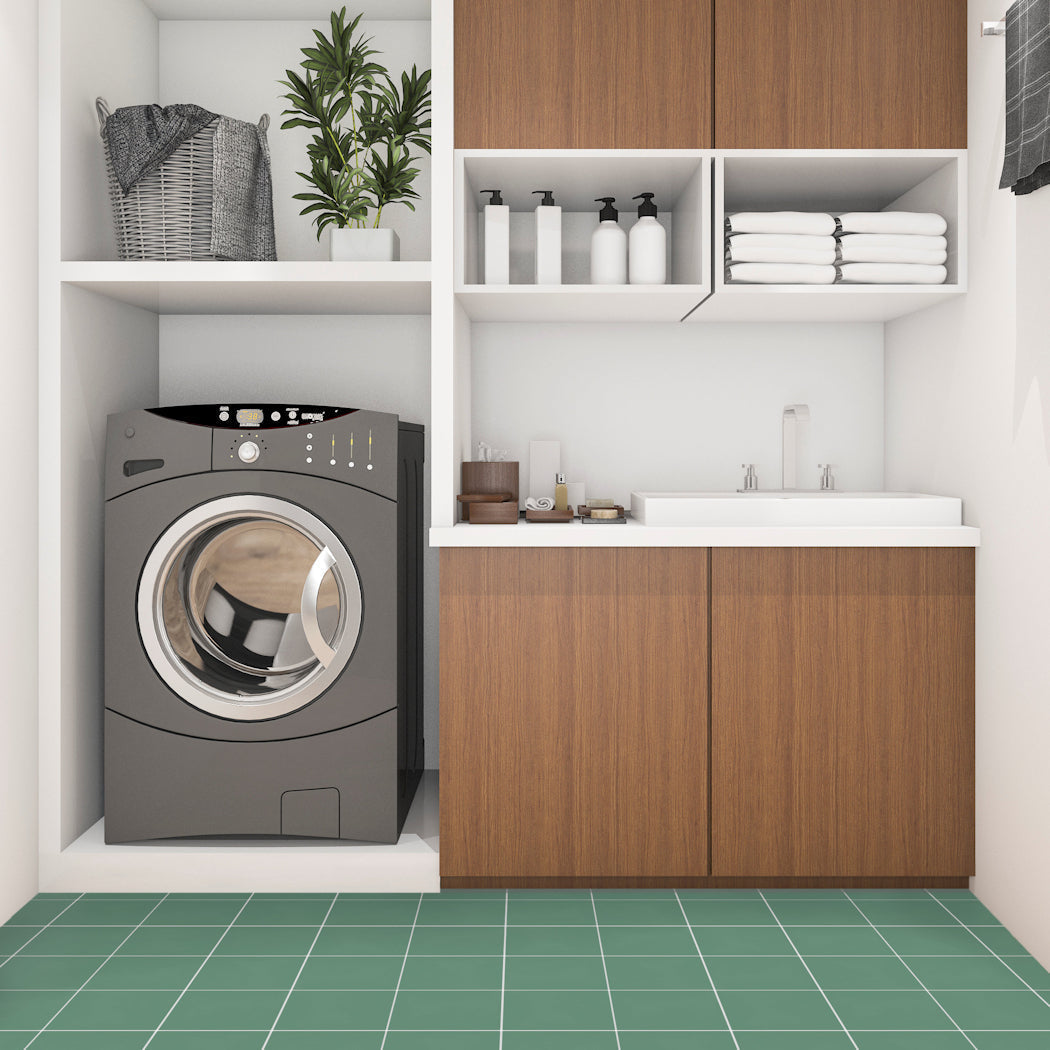 Modern laundry with front-load washer, sink, wooden cabinets, and a green 3327-Solid 4x4 floor by New York Cement Tile.