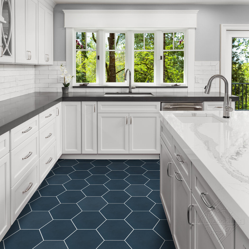 Modern kitchen with NH23-4461 black hex tile floor by New York Cement Tile, white cabinets, and large windows with green views.
