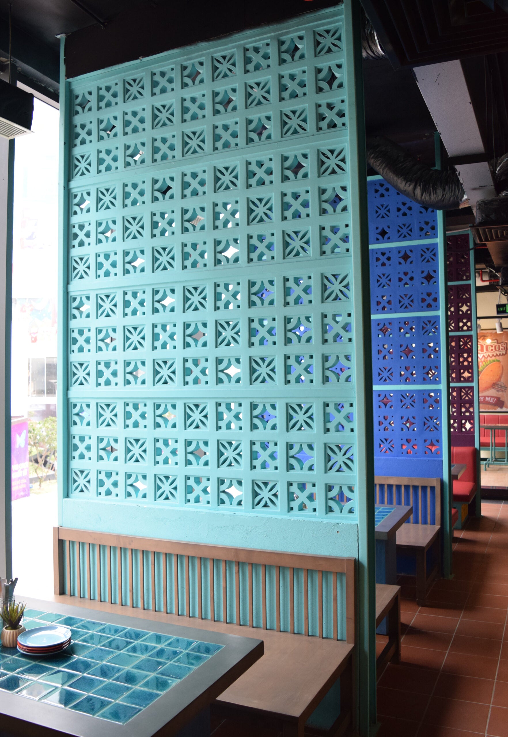 A blue wall featuring the Tahiti - NBB-003 breeze block pattern by New York Cement Tile.