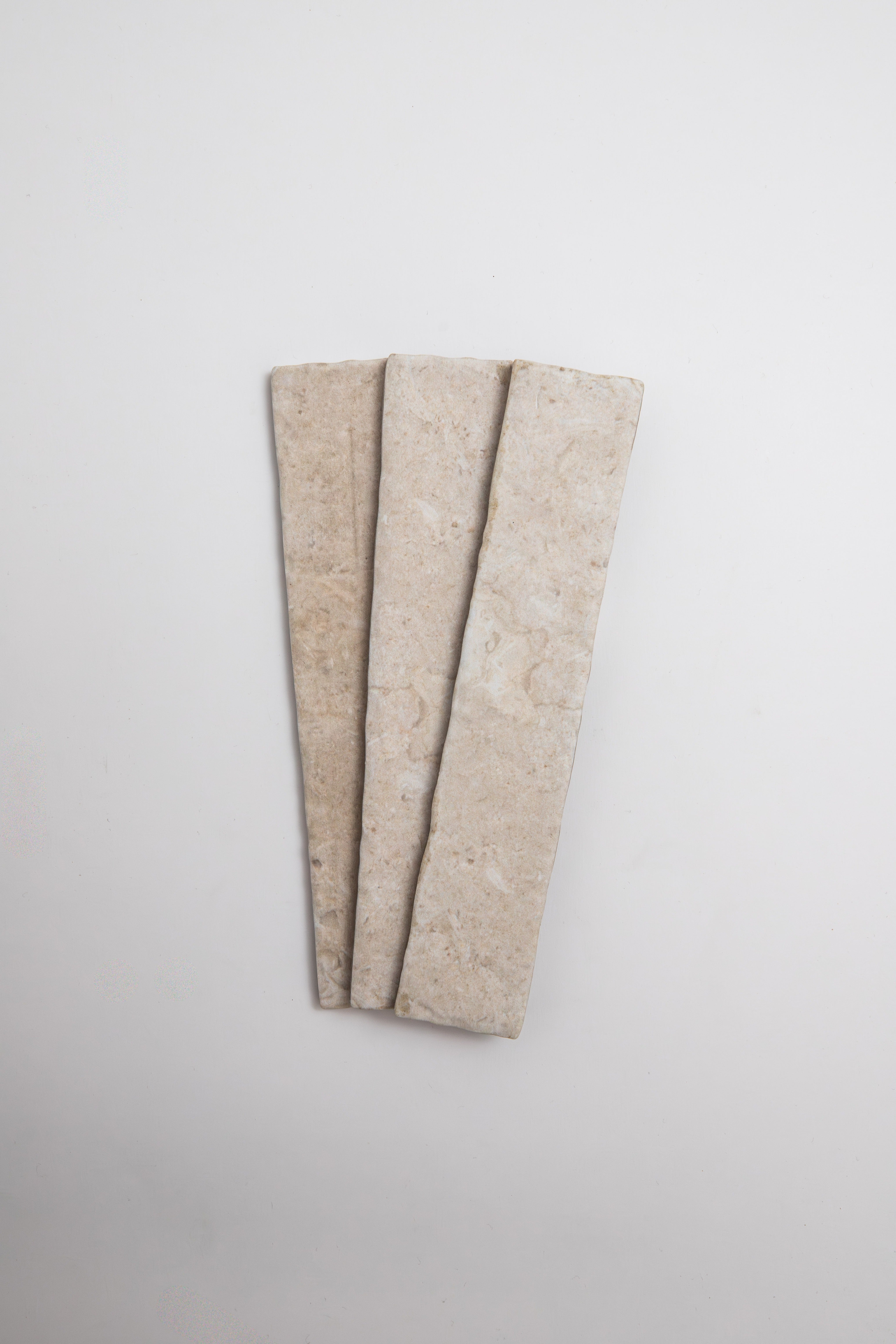 Three Toba Ivory R11 rectangular beige tiles by Toba are arranged side by side on a plain white background.