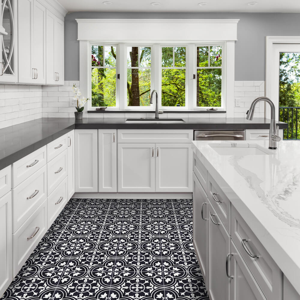 Modern kitchen with white cabinets, black countertops (N20-045 Black by New York Cement Tile), and large windows with green views.