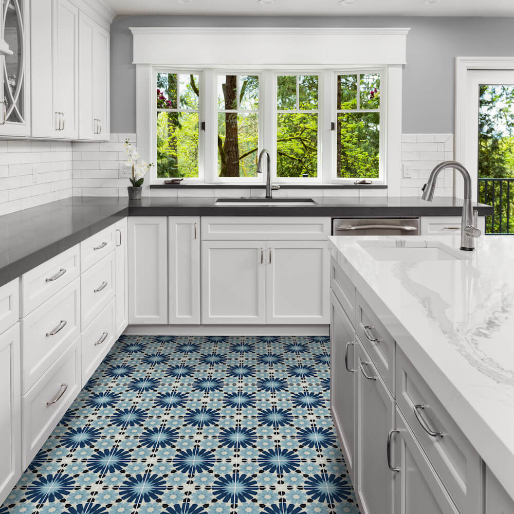 Bright kitchen with white cabinets, marble counters, and N20-029 blue tiles by New York Cement Tile, plus large windows.