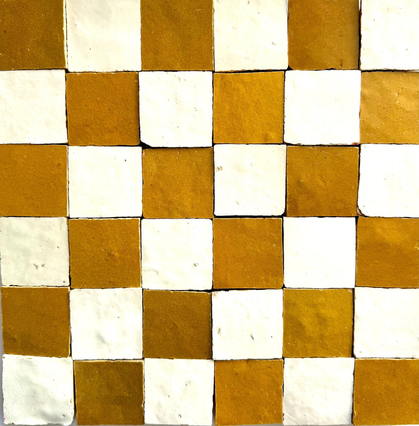 The 2X2 Checkerboard Zellige in Ivory Cloud and Caramel by New York Cement Tile features white and brown square tiles.