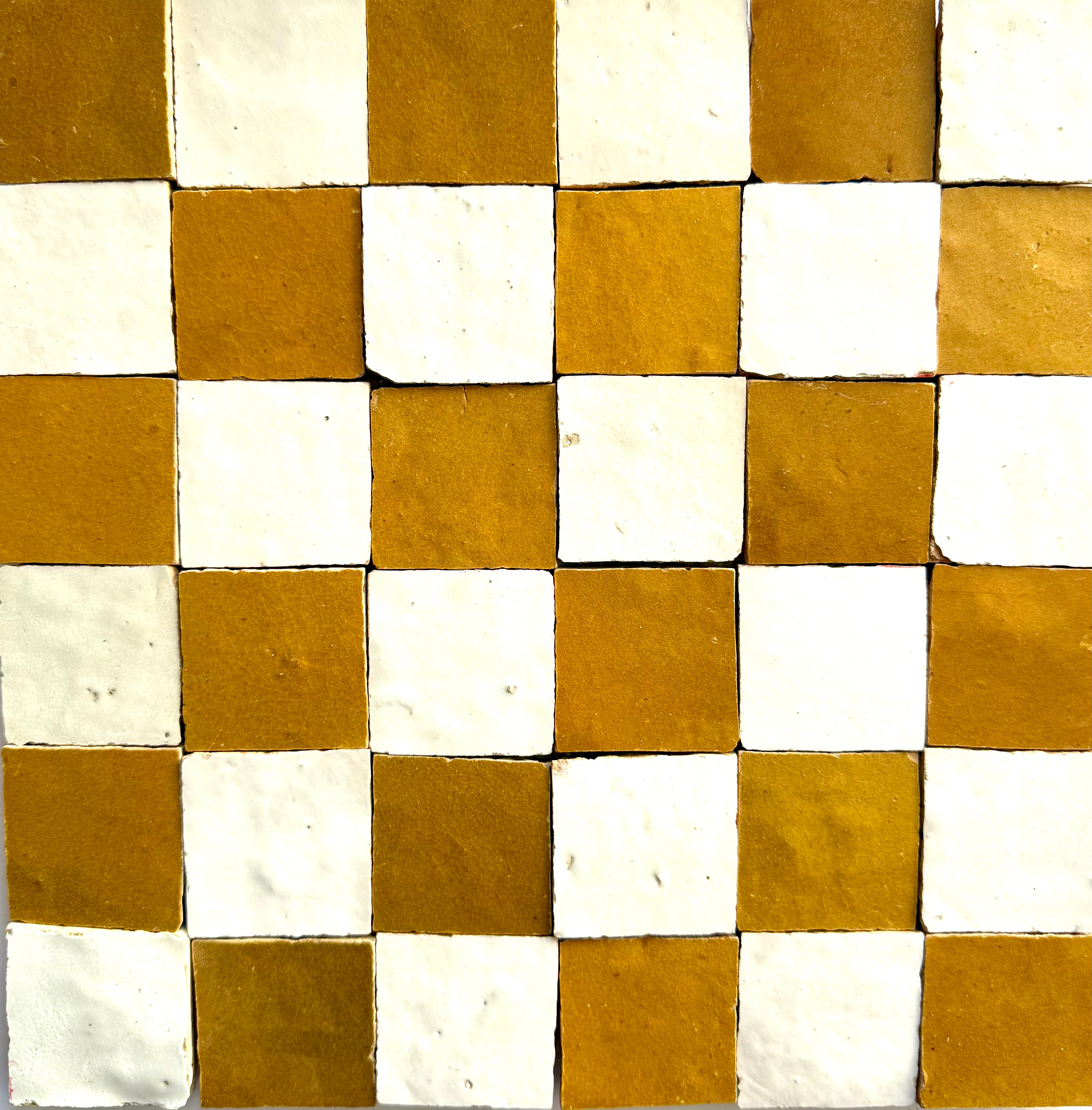The 2X2 Checkerboard Zellige in Ivory Cloud and Caramel by New York Cement Tile features white and brown square tiles.