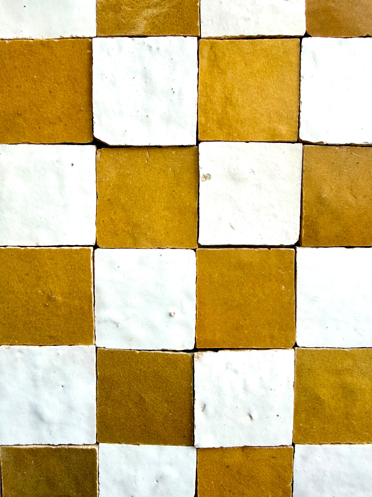 2x2 Checkerboard Zellige in Ivory Cloud & Caramel by New York Cement Tile features a textured square tile pattern.