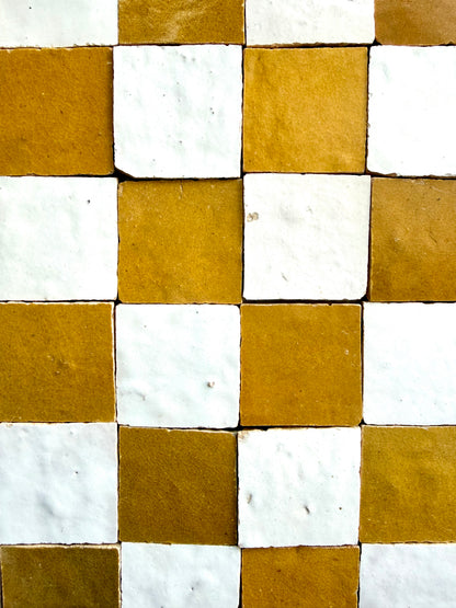 2x2 Checkerboard Zellige in Ivory Cloud & Caramel by New York Cement Tile features a textured square tile pattern.