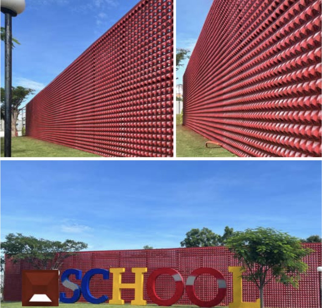 A red Hawa Sample tile by New York Cement Tile with a mid-century pattern forms the wall behind colorful SCHOOL letters.