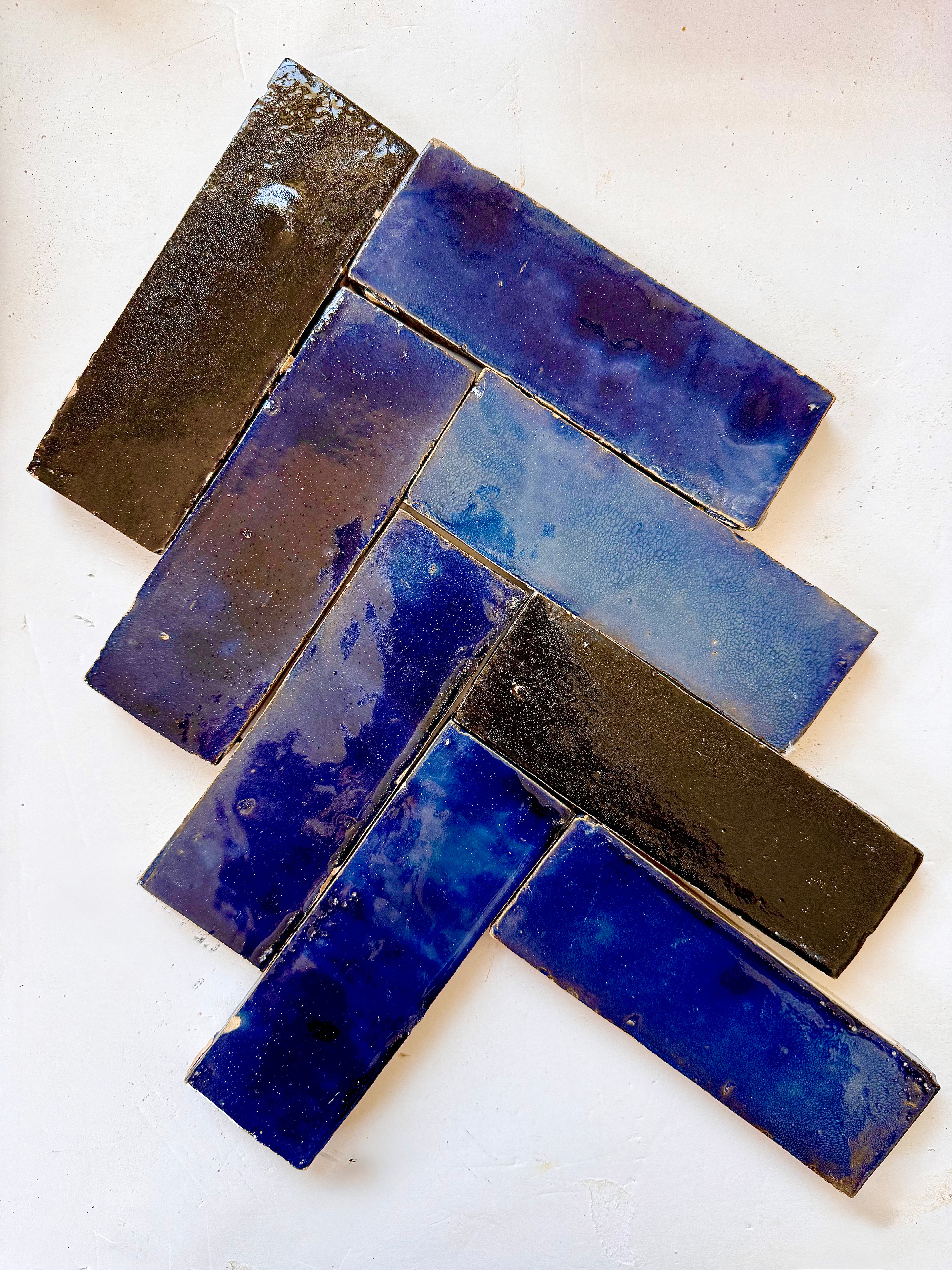 Metallic Blue (2X6) tiles by New York Cement Tile in a herringbone pattern on a white background.