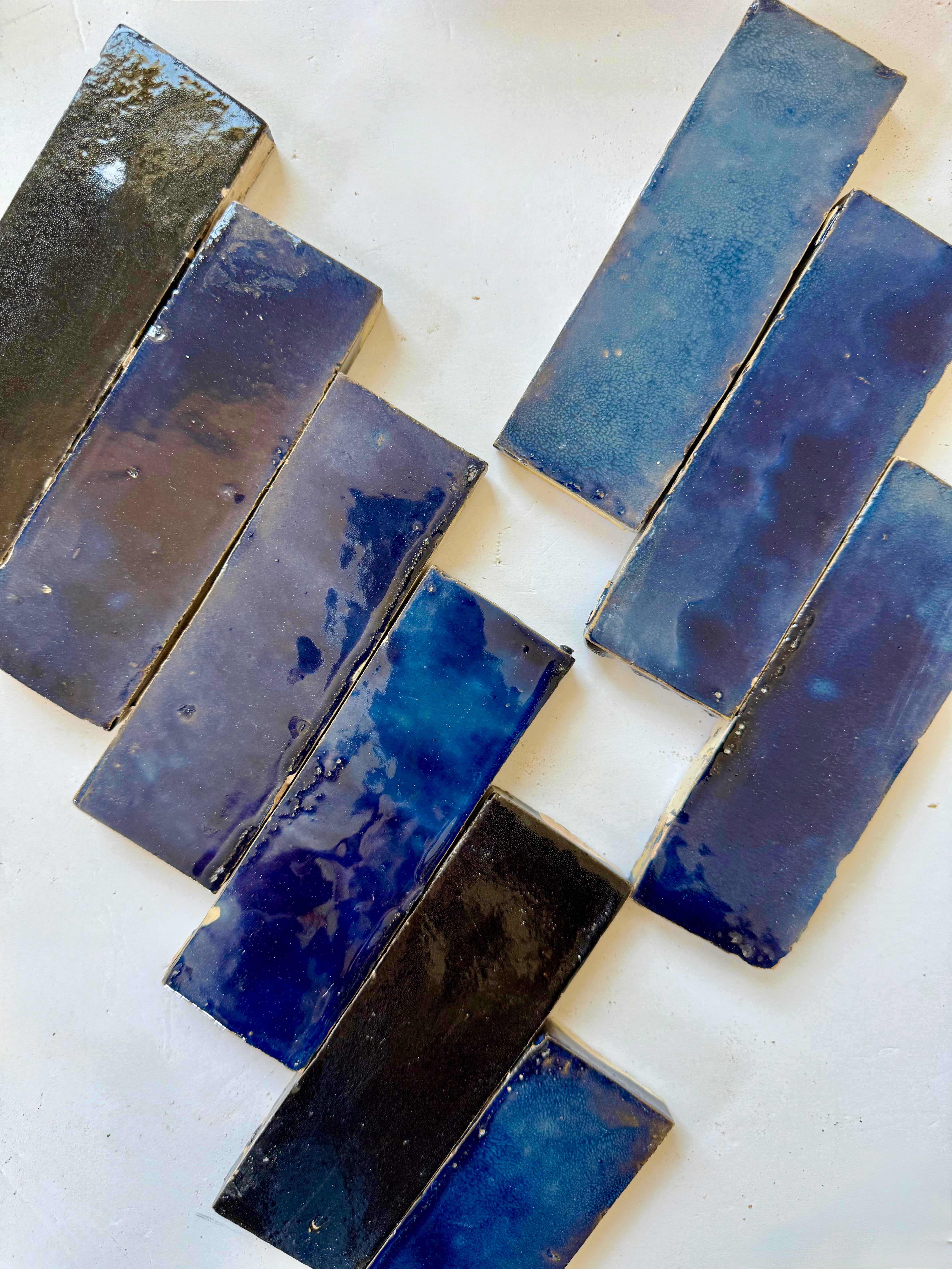 Metallic Blue (2X6) glossy tiles by New York Cement Tile, arranged diagonally on a white surface.