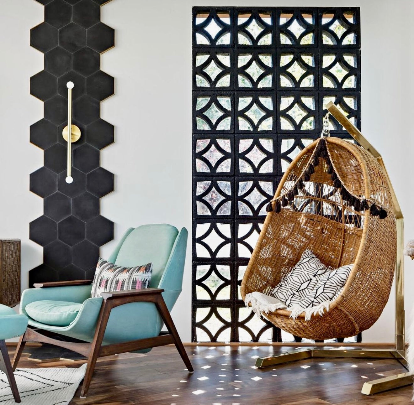 Cozy room with a hanging wicker chair, blue armchair, geometric wall art, and Large Malta by New York Cement Tile.
