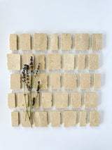 Scarpa I Travertine Mosaic Marble Mesh by New York Cement Tile, arranged with lavender on a white background.