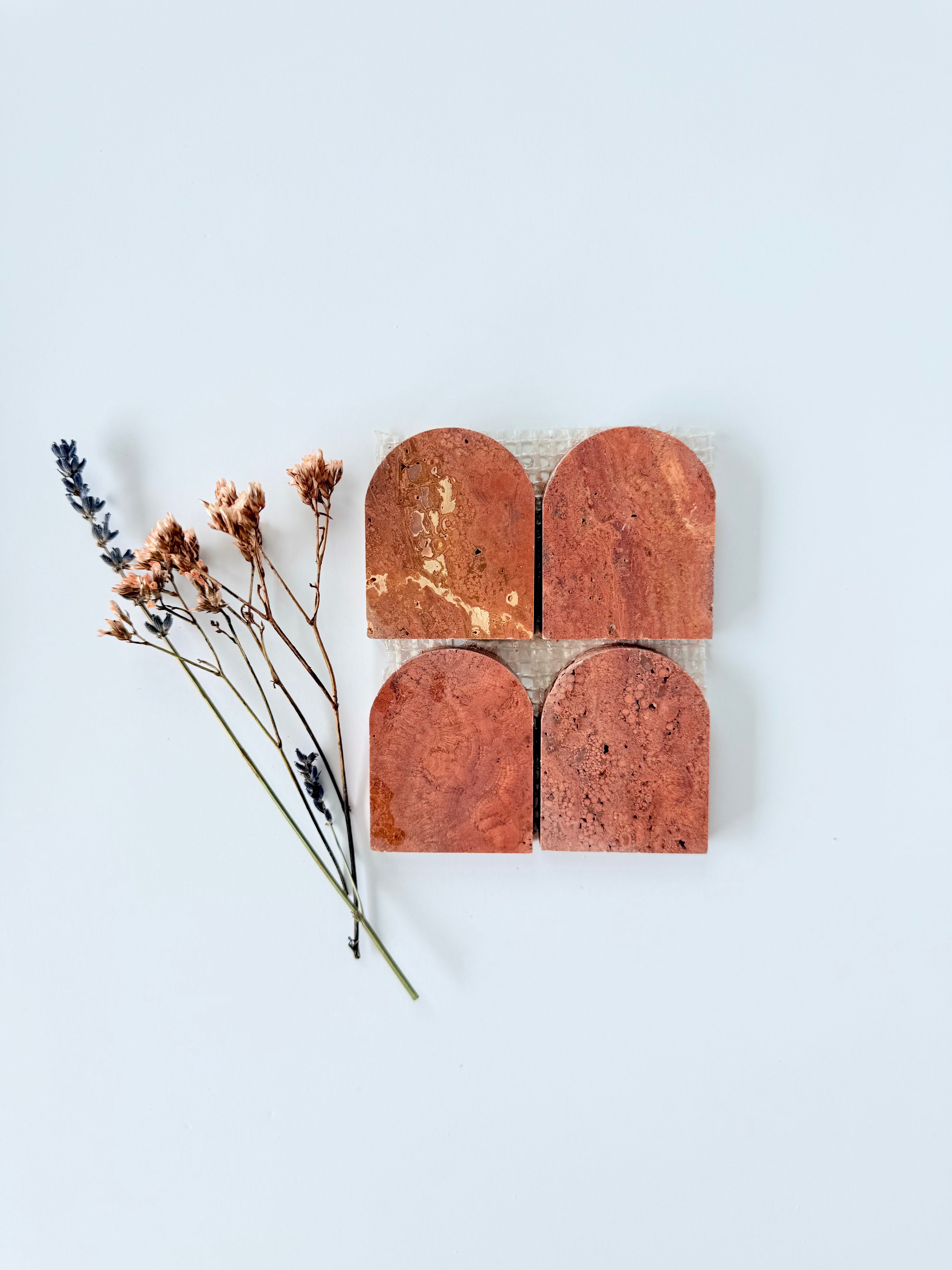 Four Scarpa I Red Travertine Arch Mosaic Marble Mesh tiles by New York Cement Tile on a light gray background.