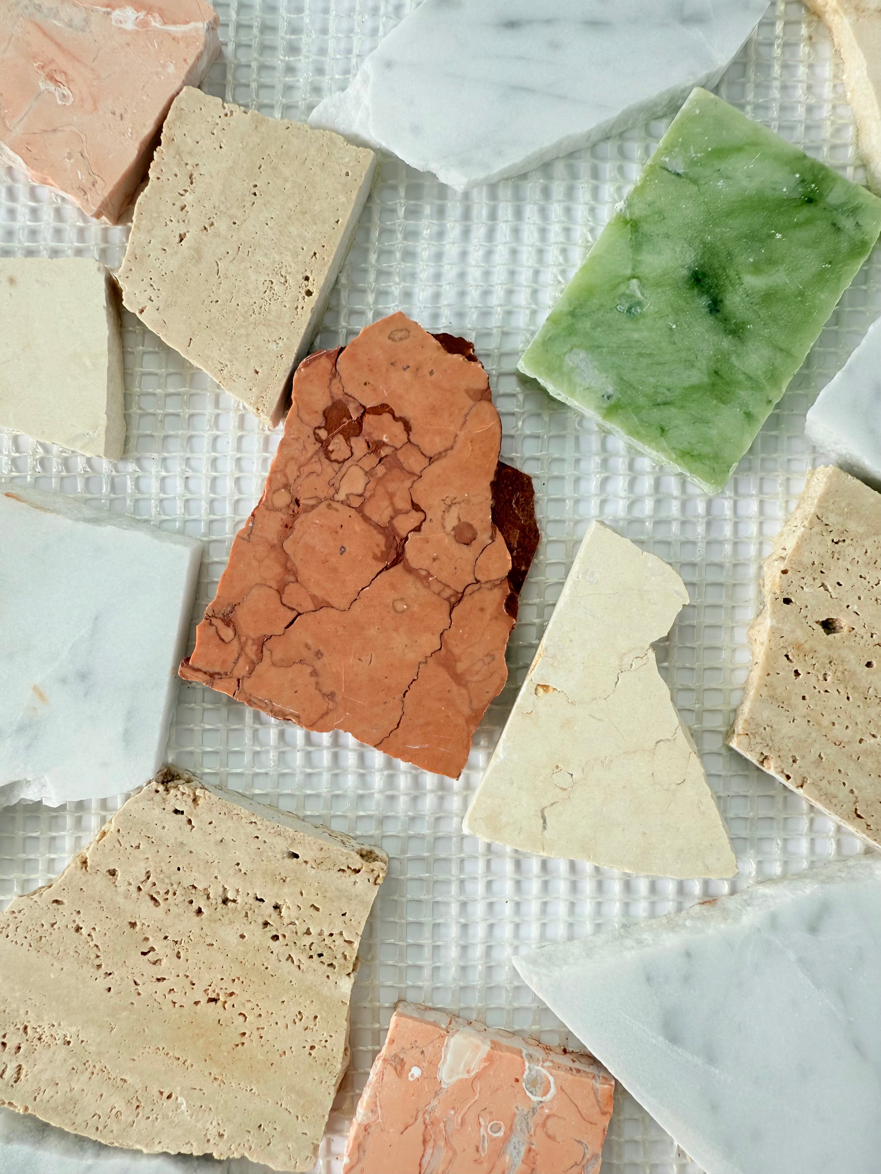 Candy - Puzzle stone tiles from New York Cement Tile arranged in a colorful grid on a white textured surface.