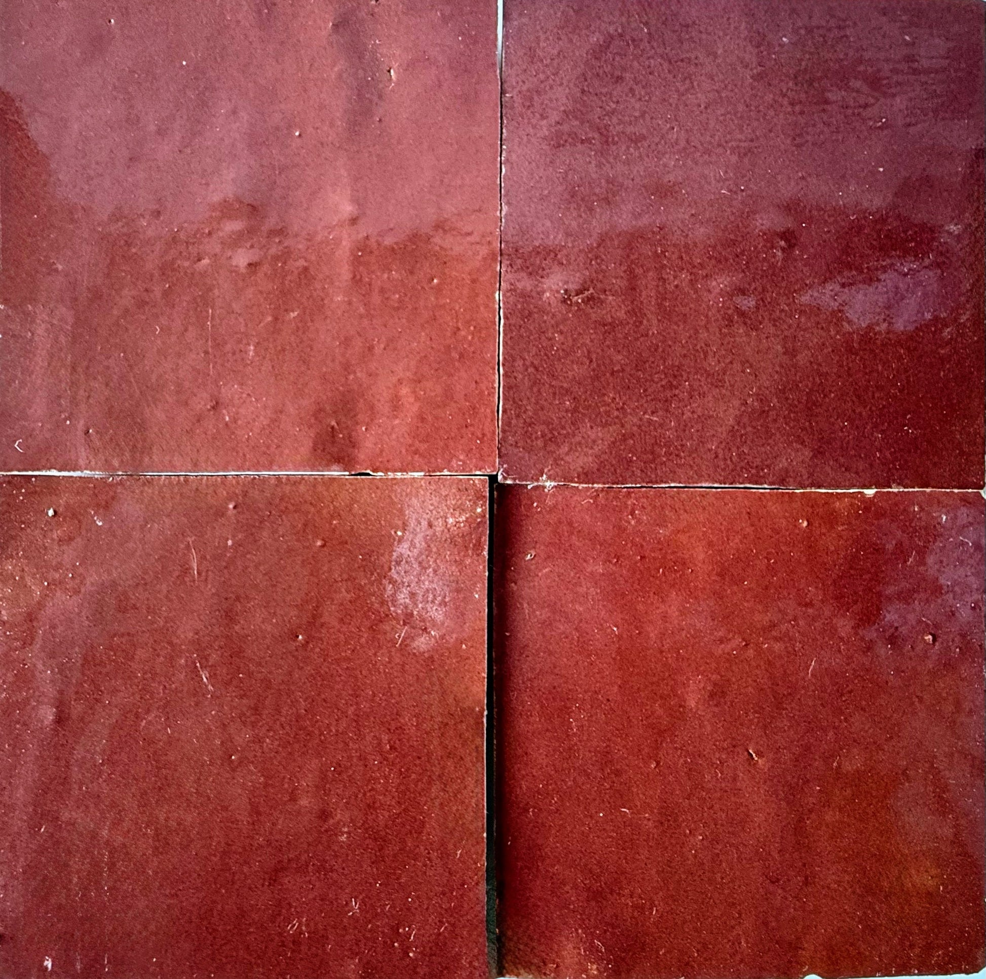 Four Chocolate Cherry tiles by New York Cement Tile arranged in a grid with visible grout lines.