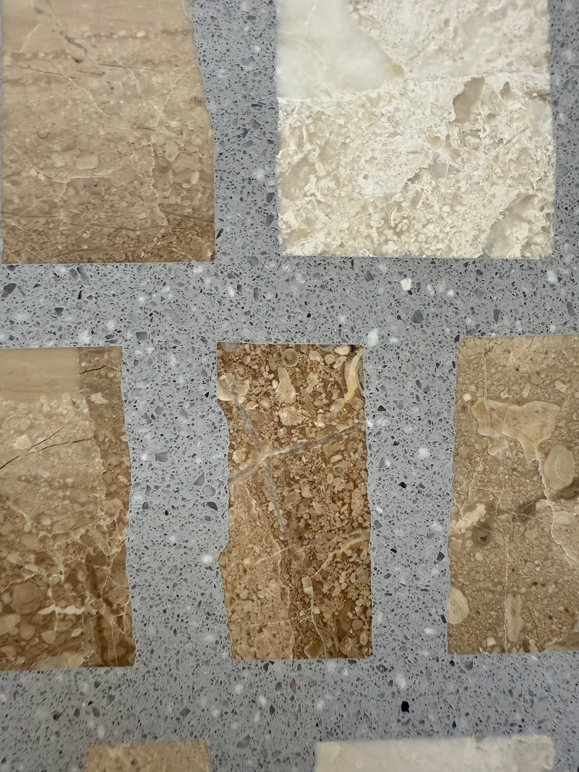 Carlo Scarpa - Cappuccino Gray by New York Cement Tile: beige and brown tiles in a grid on a speckled gray stone background.